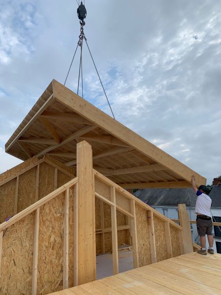 Levage d'une cassette de toiture en bois préfabriquée sur une structure à ossature bois avec panneaux OSB