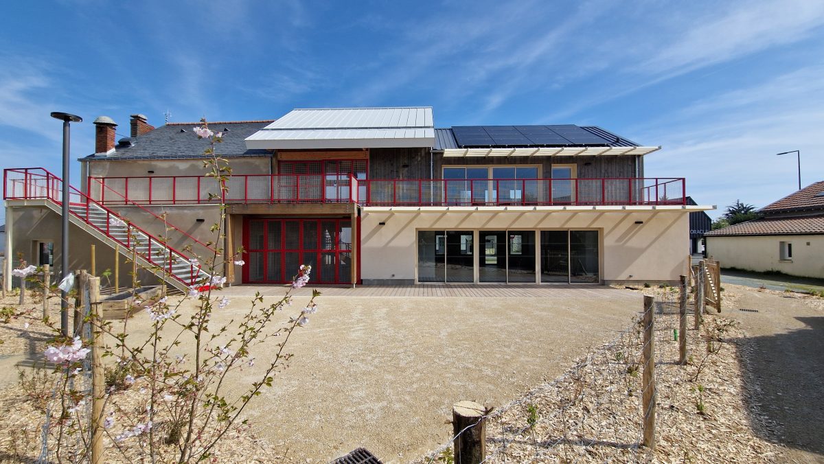 façade arrière du bâtiment, vue sur le jardin avec la végétation en premier plan
