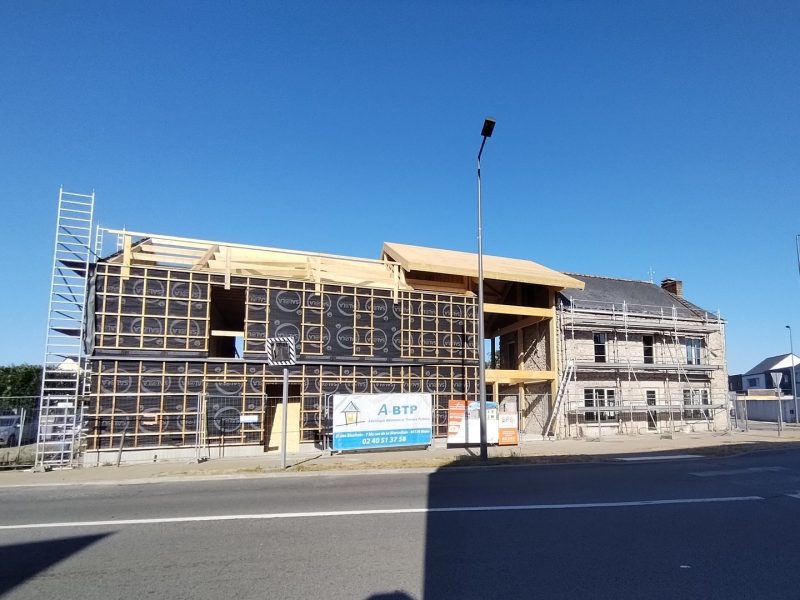 Maisons jumelées en construction avec ossature bois, isolation extérieure et échafaudages, en zone résidentielle