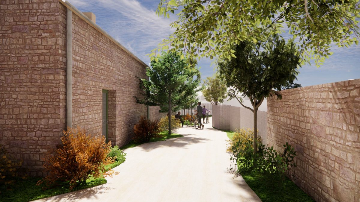 Ruelle piétonne bordée de murs en pierre claire, végétation verdoyante et arbres créant une allée ombragée