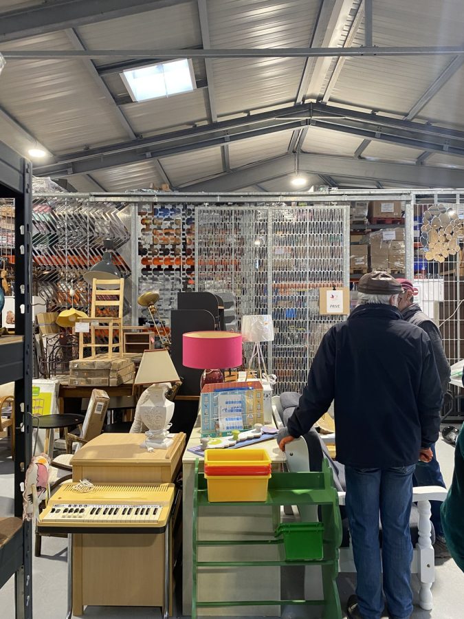 Intérieur d'un entrepôt commercial avec structure métallique et toiture translucide, aménagé en brocante