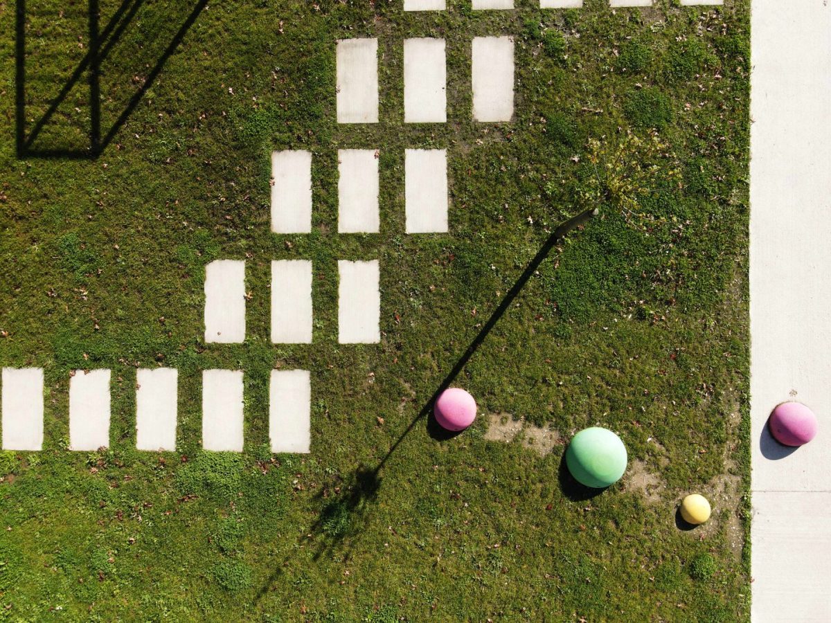 Vue aérienne d'une installation ludique sur pelouse avec rectangles blancs au sol et sphères colorées