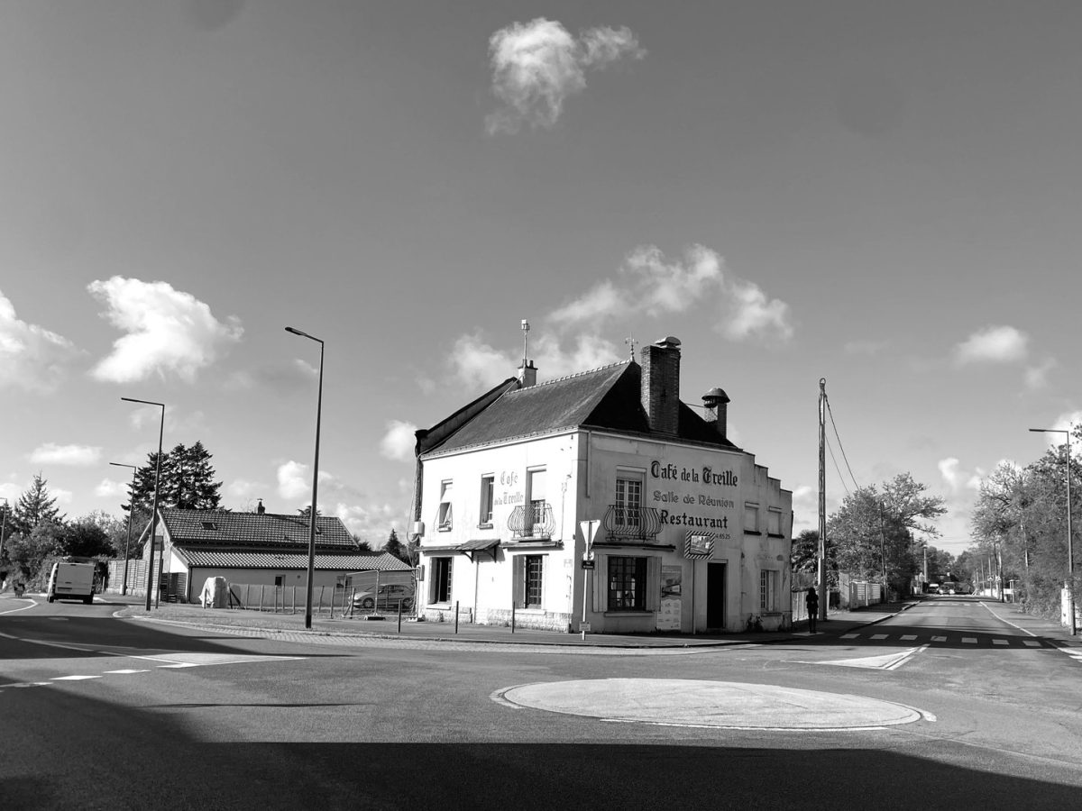 Café de la Treille, bâtiment blanc d'angle avec toiture en ardoise, situé sur un rond-point en milieu rural